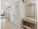 Neutral-toned hallway with a decorative mirror, table and storage closet at 5780 Midnight Pass Rd # 410, Sarasota, FL 34242