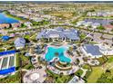 Aerial view of the community pool with seating, palm trees, and amenities at 6252 Winding Pine Dr, Nokomis, FL 34275