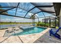 Relaxing screened-in pool and spa with serene lake view, perfect for outdoor entertaining and leisure at 6252 Winding Pine Dr, Nokomis, FL 34275