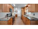 Functional kitchen design with light wood cabinets, stainless steel appliances, and solid countertops at 649 Fairmount Dr, North Port, FL 34287