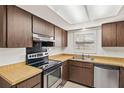 Cozy kitchen featuring wooden cabinets, stainless steel appliances and light countertops at 6547 Samoa Dr, Sarasota, FL 34241