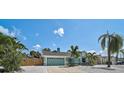 Charming turquoise home featuring a well-manicured lawn with tropical landscaping and a two-car garage at 6924 34Th W Ave, Bradenton, FL 34209