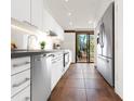Modern kitchen featuring sleek white cabinets, stainless steel appliances, and view to the backyard at 7 Sandy Cove Rd, Sarasota, FL 34242