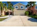 Charming two-story home boasts a well-manicured lawn and beautiful palm trees, creating a welcoming curb appeal at 7168 Chatum Light Run, Bradenton, FL 34212
