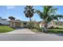 Inviting single-story home featuring a covered carport, well-kept lawn, and tropical landscaping at 780 Jungle Queen Way, Longboat Key, FL 34228