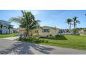 Charming single-story home with a well-maintained lawn and lush tropical landscaping with palm trees at 780 Jungle Queen Way, Longboat Key, FL 34228