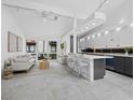Bright, open-concept living room with modern furnishings, island seating, and light, neutral decor at 800 S Blvd Of The Presidents # 19, Sarasota, FL 34236