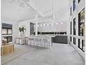 Bright, open-concept living room with modern furnishings, island seating, and light, neutral decor at 800 S Blvd Of The Presidents # 19, Sarasota, FL 34236