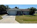 Well-maintained home featuring an attached garage, manicured lawn, and mature trees at 807 Mohawk Rd, Venice, FL 34293