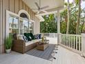 Cozy outdoor seating area on a covered porch with comfortable furniture and scenic views at 8871 Fishermens Bay Dr, Sarasota, FL 34231