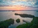 Breathtaking sunset over the tranquil waterfront with a pier, offering stunning views at 8871 Fishermens Bay Dr, Sarasota, FL 34231