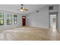 Bright living room with tile floors, ceiling fan, and ample natural light from the large windows at 920 36Th W St, Bradenton, FL 34205