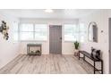 Inviting entryway with light wood-look floors, lots of natural light, decorative mirror and accent table at 104 Shoreland Dr, Osprey, FL 34229