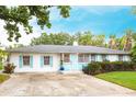Charming single-story home featuring light blue shutters, a well-manicured lawn, and a concrete driveway at 104 Shoreland Dr, Osprey, FL 34229