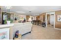 Open-concept living room with tile flooring, neutral tones, and seamless flow to the kitchen, great for entertaining at 10432 Sandpiper W Rd, Bradenton, FL 34209