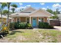 Inviting single-story home with a blue front door framed by decorative shrubs and manicured lawn at 1052 32Nd St, Sarasota, FL 34234