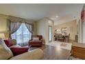 Cozy living room with hardwood floors, large window, comfortable seating, and dining area at 12805 Raysbrook Dr, Riverview, FL 33569