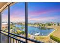 Serene water view from a lanai featuring boats docked along a canal and a picturesque sky at 1349 Aqui Esta Dr # 143, Punta Gorda, FL 33950