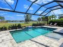 Inviting screened-in pool with waterfall feature and tranquil views of the golf course and lake at 15037 Montello Way, Lakewood Ranch, FL 34211