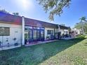 The back of the villa features a brick patio, sliding glass doors, and a well-maintained lawn for outdoor enjoyment at 1526 Mission Hills Blvd # 18B, Clearwater, FL 33759