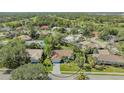 Aerial shot showcasing a home with a red tile roof, surrounded by lush landscaping in a residential neighborhood at 2115 Timucua Trl, Nokomis, FL 34275
