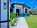 Home's front entrance with stone accents and lush landscaping to welcome guests and boost curb appeal at 22 Medalist Cir, Rotonda West, FL 33947