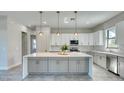 Bright kitchen featuring gray cabinets, stainless steel appliances, and an island with marble countertops at 22 Medalist Cir, Rotonda West, FL 33947