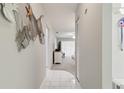 Inviting hallway featuring tile and carpet, with coastal decorations and a view into the living area at 2220 Stickney Point Rd # 531, Sarasota, FL 34231