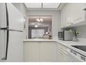Bright kitchen with white cabinets and appliances, and a convenient pass-through to the living room at 2220 Stickney Point Rd # 531, Sarasota, FL 34231