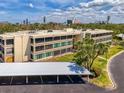 Exterior elevation of condo complex with carports and lush landscaping at 225 Hourglass Way # 101, Sarasota, FL 34242