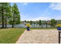 Scenic backyard view featuring a paved patio overlooking a tranquil pond with a fountain feature at 2254 50Th Street E Cir, Palmetto, FL 34221