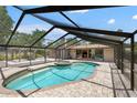 Screened pool with a spa and stone tile, set in a private backyard oasis at 2778 Greendale Dr, Sarasota, FL 34232