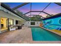Inviting screened-in pool area featuring comfortable seating and a vibrant mural for outdoor enjoyment at 3698 Glen Oaks Manor Dr, Sarasota, FL 34232