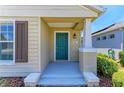 Inviting front porch featuring a teal door, a tiled entryway, and white support beams at 4031 Cottage Hill Ave, Parrish, FL 34219