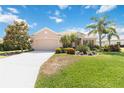 Charming home with a well-maintained lawn, mature trees, and a spacious driveway leading to an attached two car garage at 4262 70Th Street E Cir, Palmetto, FL 34221