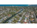 Stunning aerial view of a waterfront property with lush landscaping and canal access to the bay at 5024 Commonwealth Dr, Sarasota, FL 34242