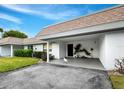 Inviting covered carport features tropical landscaping, fresh paint, and ample space at 565 Sutton Place, Longboat Key, FL 34228