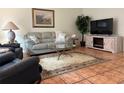 Cozy living room featuring a comfortable sofa, modern television, neutral decor, and tile floors at 5657 Westwind Ln, Sarasota, FL 34231