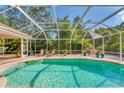 An inviting swimming pool is surrounded by a screened enclosure, providing a private outdoor space at 6620 Saint James Xing, University Park, FL 34201
