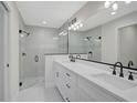 Modern bathroom featuring double vanity, sleek fixtures, and glass-enclosed shower with tiled walls at 7116 Quarry St, Englewood, FL 34224