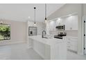 Bright kitchen with white cabinetry, stainless steel appliances, and center island with pendant lighting at 7116 Quarry St, Englewood, FL 34224