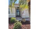 Inviting front entrance with a charming palm tree and decorative landscaping at 7360 Talon Bay Dr, North Port, FL 34287
