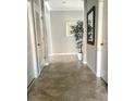 Elegant hallway with neutral tile flooring and a decorative mirror and plant at 7360 Talon Bay Dr, North Port, FL 34287