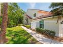 Exterior view of the condo with walkway, mature trees, and landscaping showcasing its peaceful setting at 7639 Fairway Woods Dr # 605, Sarasota, FL 34238
