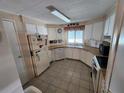 Functional kitchen featuring ample cabinet space, tiled floors, and essential appliances at 808 53Rd E Ave # 229, Bradenton, FL 34203