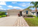 Lovely home featuring a two-car garage, mature landscaping, a brick pathway, and a welcoming entryway at 1717 Bonita Bluff Ct, Ruskin, FL 33570