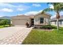 Well-kept home with neutral tones, stone accents, a two-car garage, and an attractive brick walkway at 1717 Bonita Bluff Ct, Ruskin, FL 33570