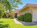 Inviting front entrance with a brick pathway, manicured bushes, and red terracotta roof at 1720 Kestral Park S Way # 49, Sarasota, FL 34231