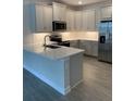 Well-equipped kitchen with stainless steel appliances, quartz countertops, and stylish cabinetry at 240 Ibiza Loop, Venice, FL 34292