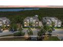 Beautiful townhouse with neutral tones, lush landscaping, and a view of the water and trees in the background at 241 Sapphire Lake Dr # 201, Bradenton, FL 34209